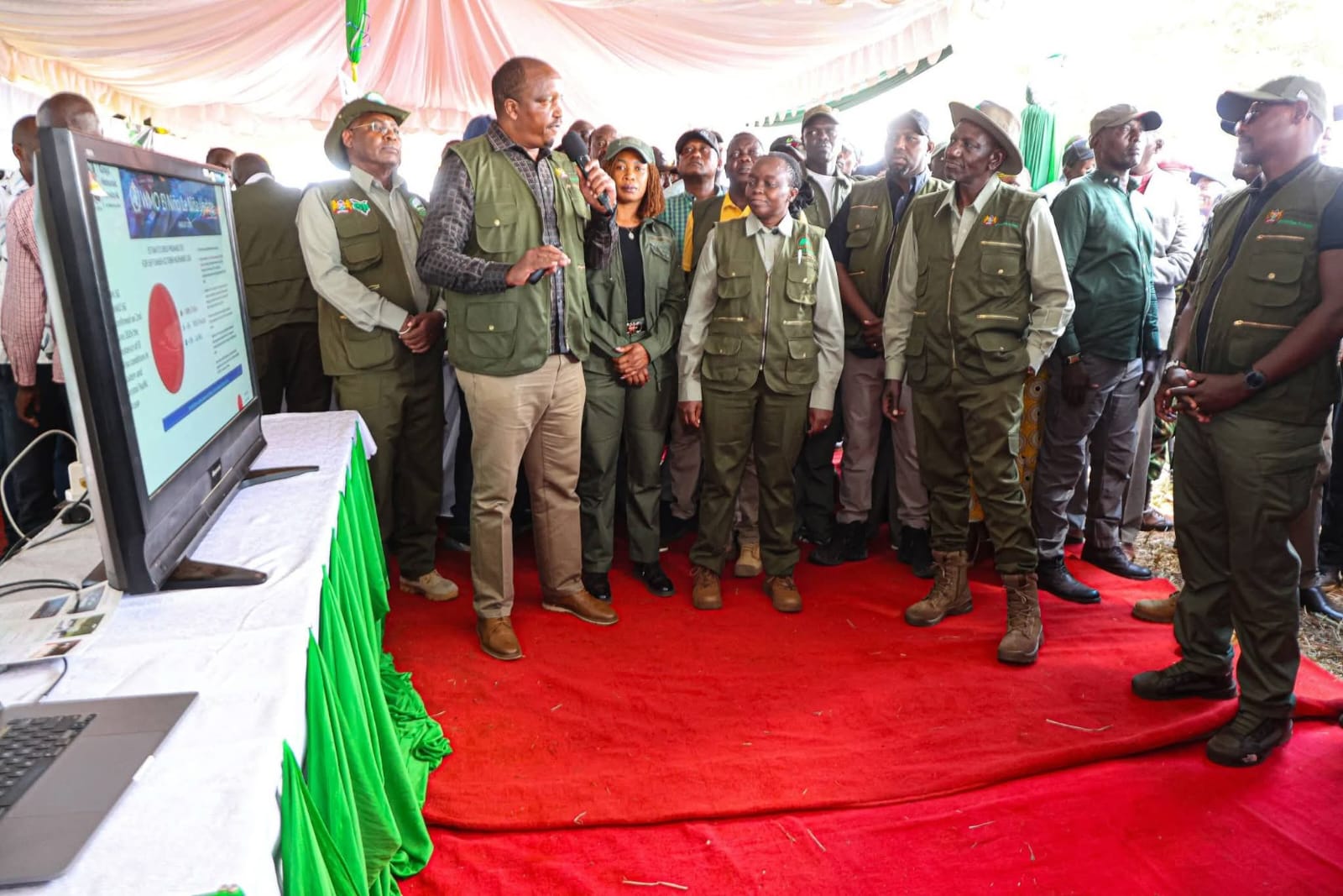 President William Ruto listening to the weatherman during Mazingira Day Celeberations in Trans Nzoia County
